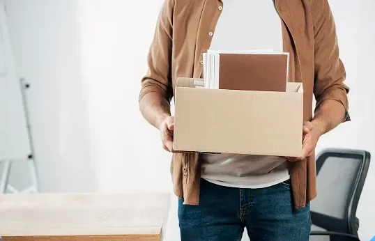 Employee carrying a packed box during a San Diego commercial office move